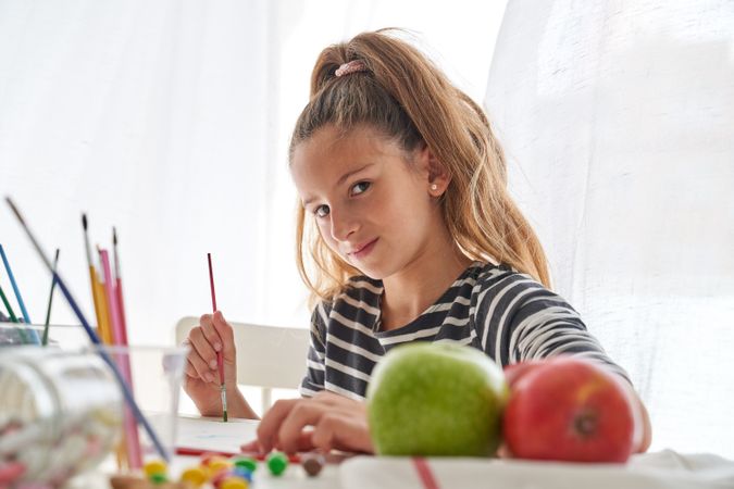 Cute girl painting with paintbrush