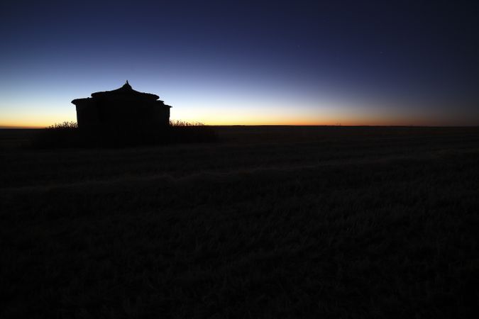 Aged house in rural countryside under starry sky