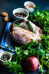 Raw chicken on kitchen slab with seasoning
