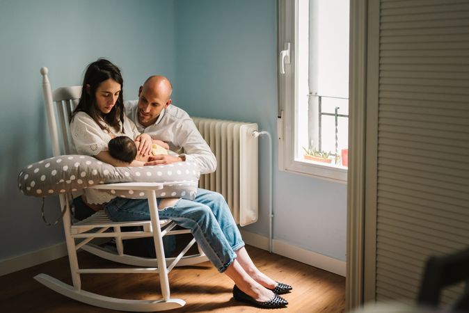Happy parents feeding baby