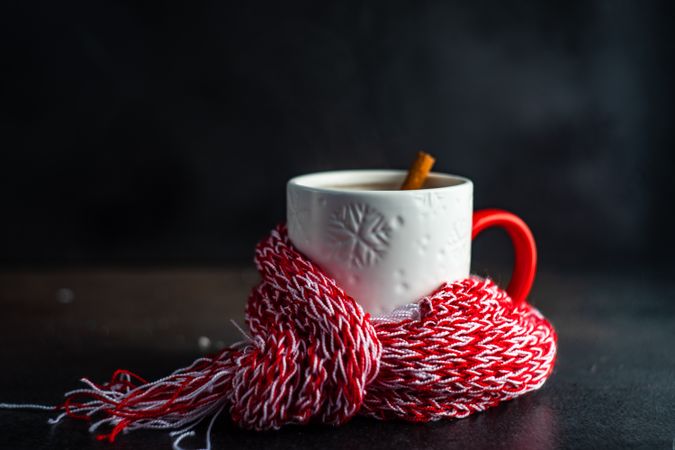 Side view of mug wrapped in red woolen scarf