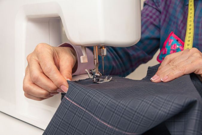 Seamstress hands working on a sewing machine