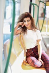 Portrait of Arab woman sitting in train carriage resting head on hand