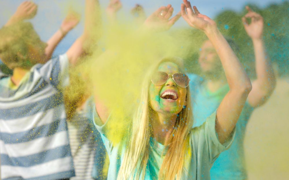 Portrait of a Blonde Woman Dances in Celebration of Holi Festival With Her Friends.