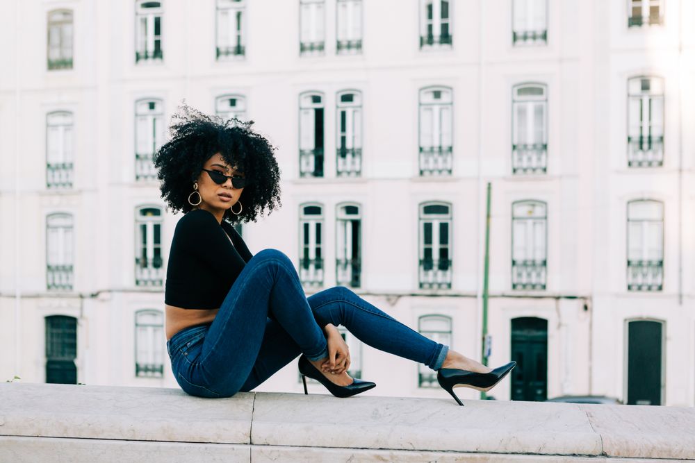 Fashionable Black female relaxing in city