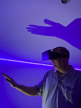 Man wearing virtual reality headset indoor in purple lit room