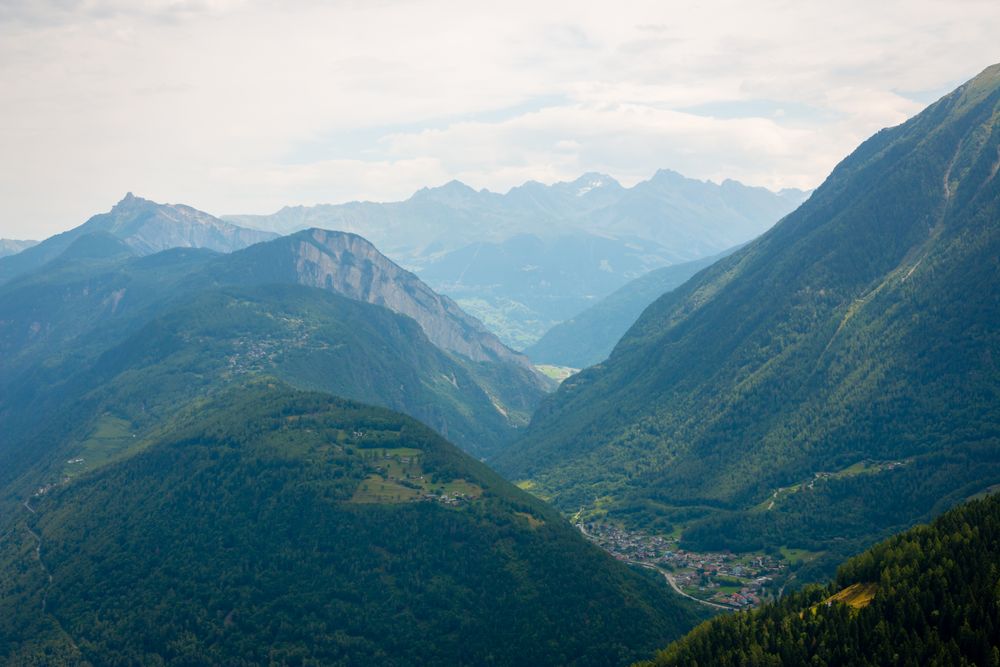 Densely populated town at foot of green mountains