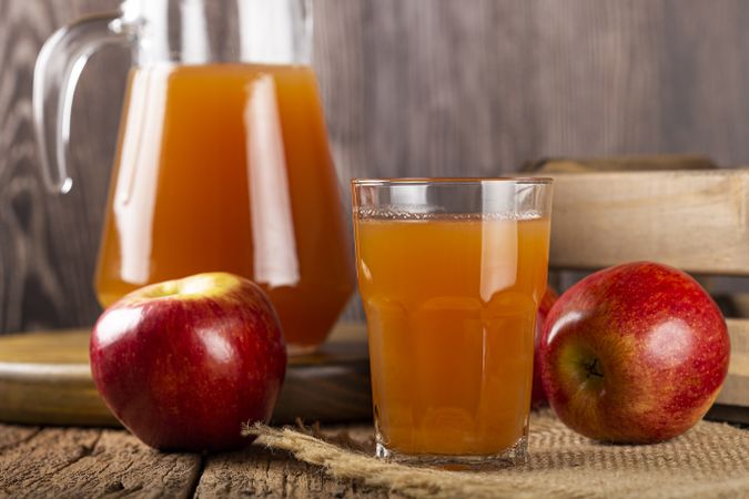 Apple juice and red apples on the table.