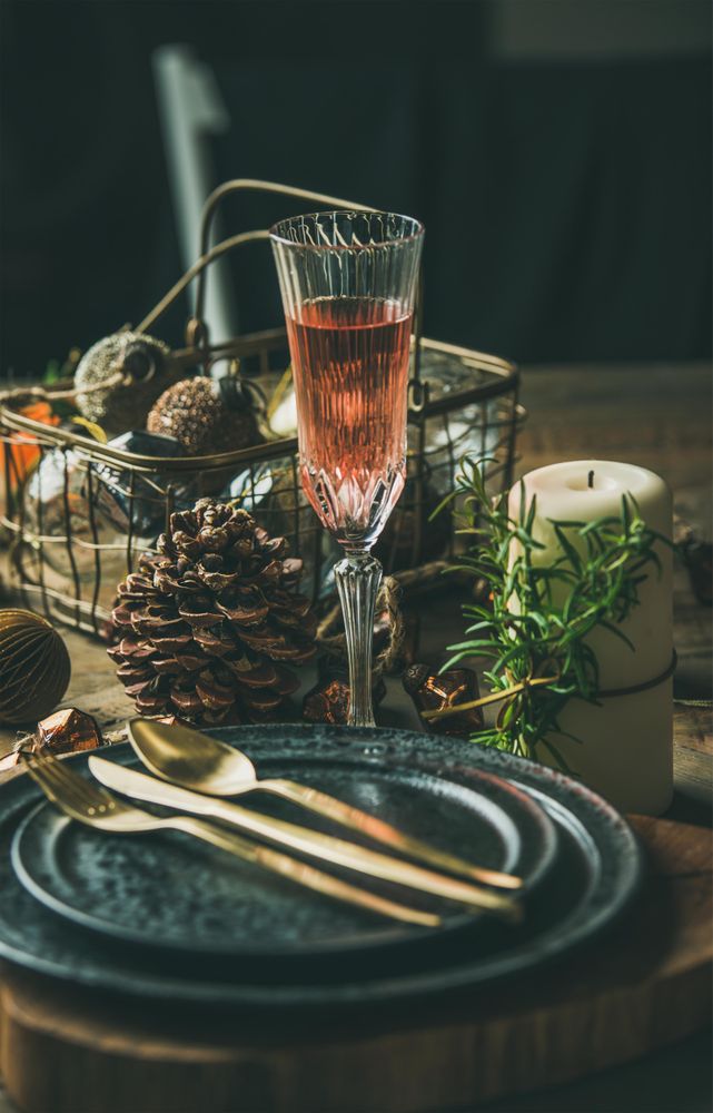 Table setting with crystal flute of Champagne, pinecone, and candle