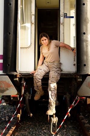 Military woman sitting near van