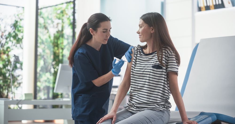 Professional Female Nurse Is Performing Injection And Putting A Patch On. Public Healthcare Concept.