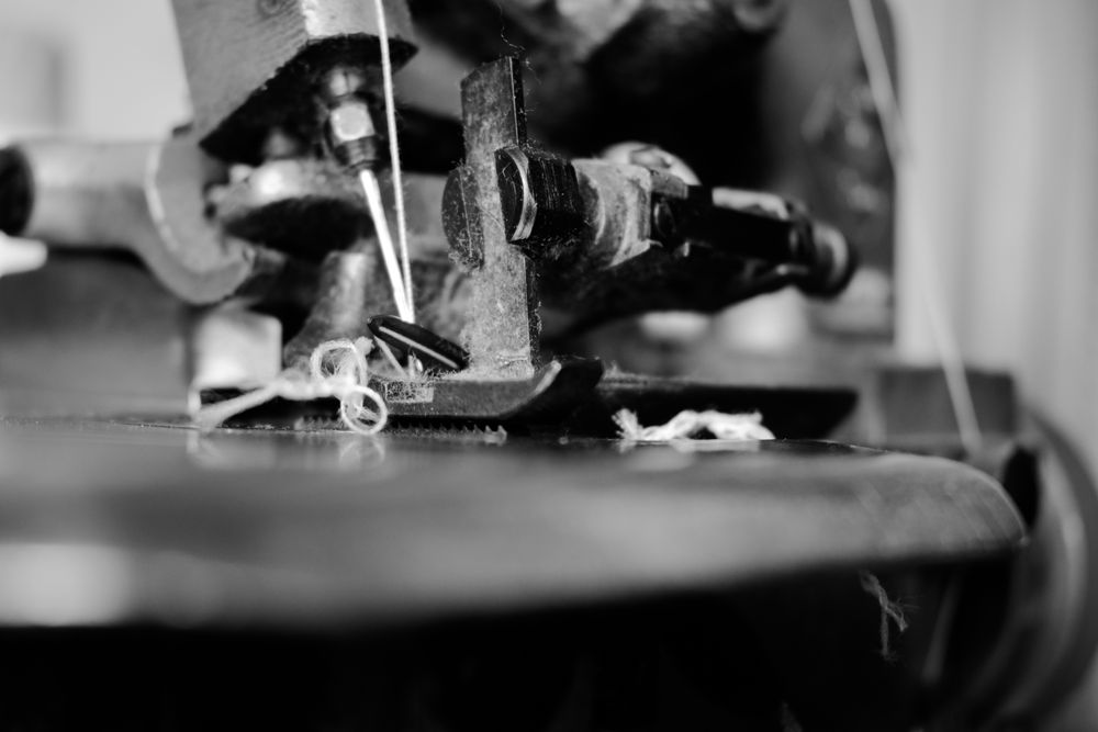 Close up of string through sewing machine needle