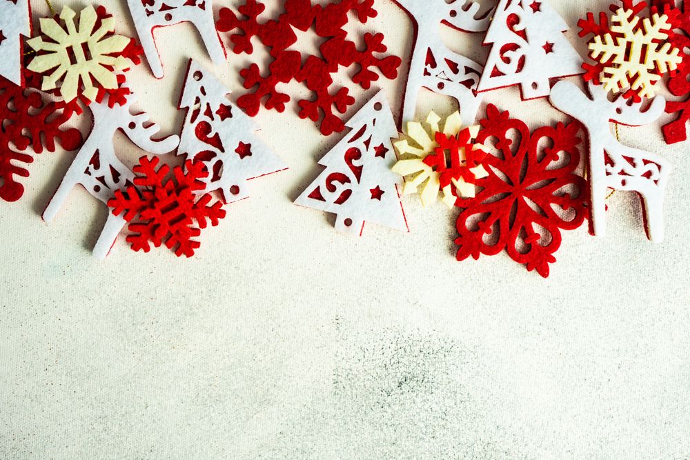 Variety of flat red Christmas ornaments scattered on marble