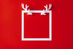 Reindeer antlers with light-colored frame on red background