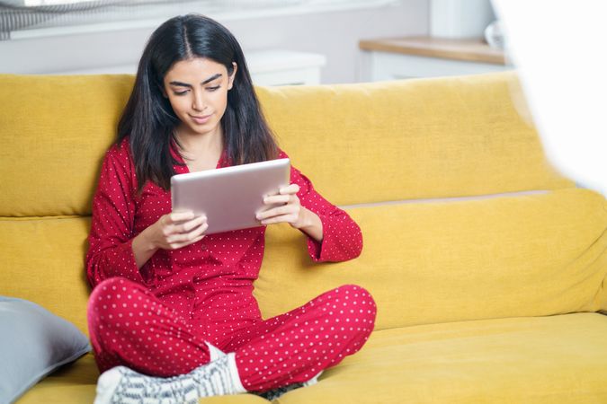 Female relaxing at home and using a tablet