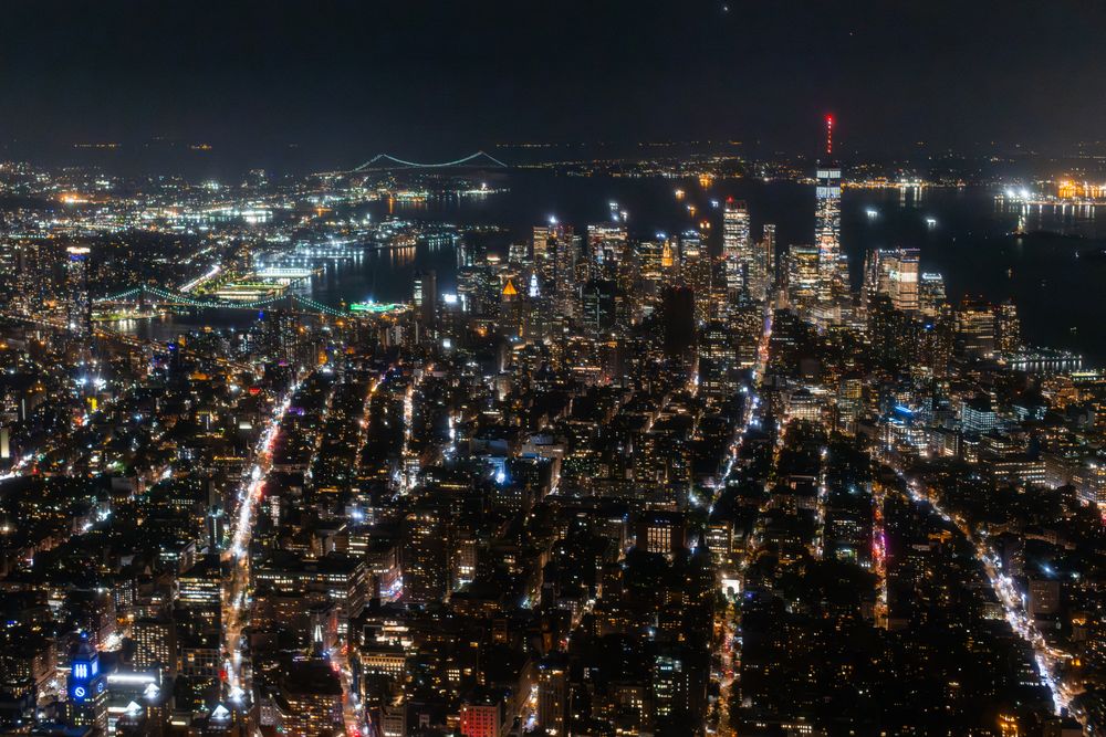 Helicopter Tour of New York City Architecture at Night. Fly-By Over Midtown Manhattan Office Buildings and Skyscrapers. Aerial Urban Landscape with Lights at Night