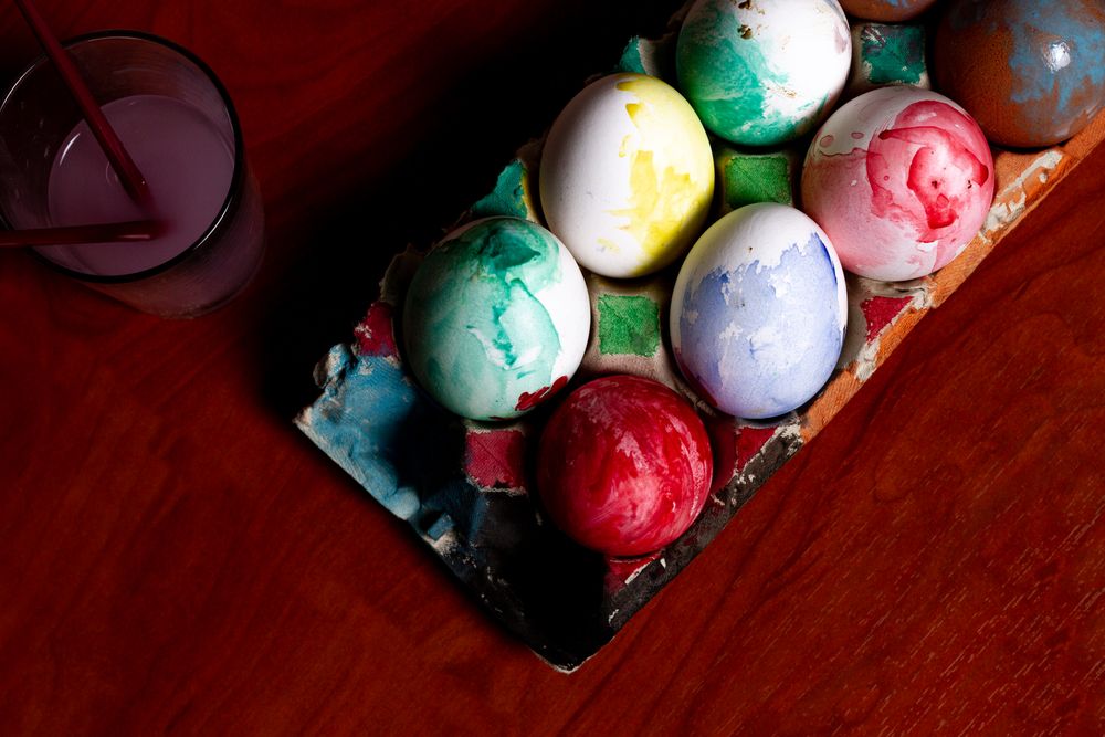 Set of painted Easter eggs in container on table