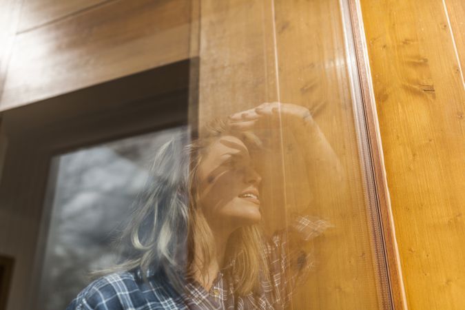 Woman reflection in a windows at home