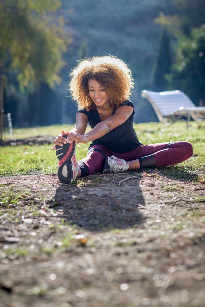 Happy woman warming up legs outside
