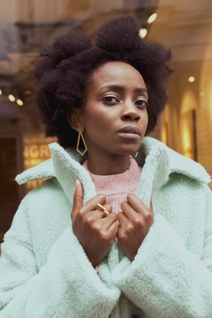 Portrait of woman with afro hair wearing turquoise jacket