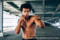 Black male athlete doing boxing training under a bridge 4983m5