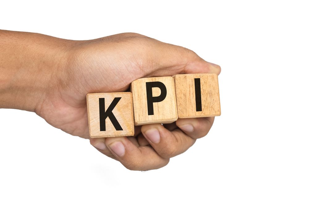 male hand holding KPI letter symbol on wooden blocks isolated