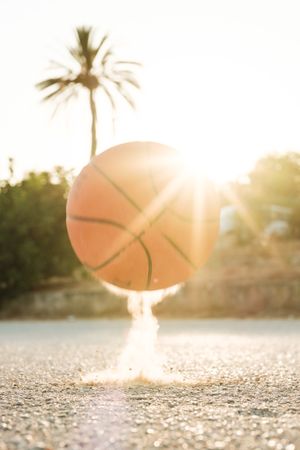 Basketball on asphalt in sunshine