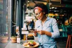 Woman taking a picture of her food in a cafe