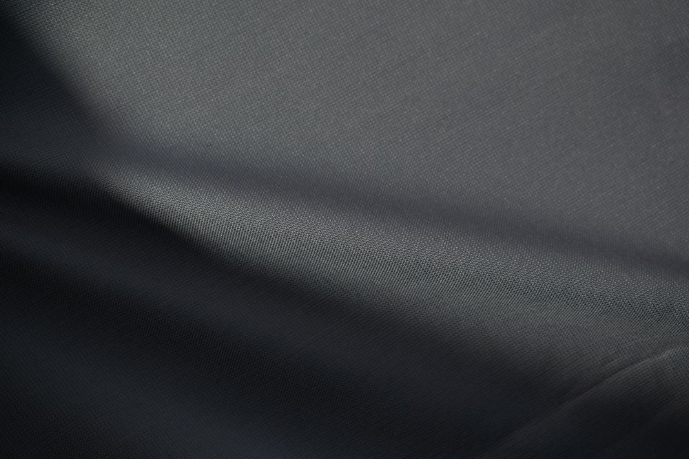 Wavy dark grey fabric background texture. shiny, glossy and elegant background.