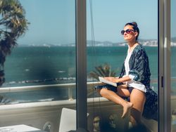 Content woman with book on balcony