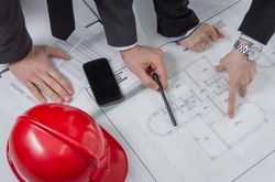 Above view of architects hands revising a house project