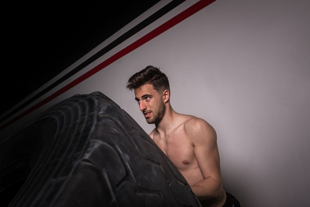 Man flipping big tires in gym