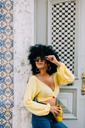 Happy Black female leaning on vintage door