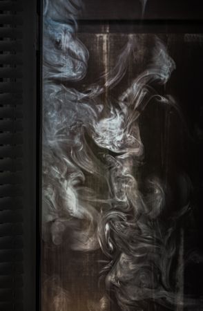 Smoke swirling next to a wooden wall