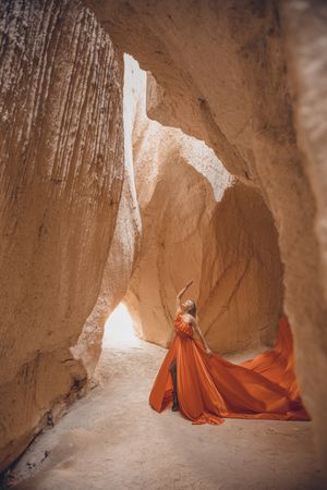 Woman in red dress standing in canyon rock formation