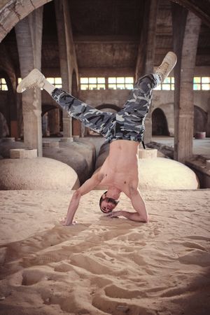 Man performing handstand while breaking dance in abandoned building