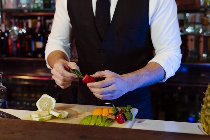 Barman working preparing fruits for cocktail drinks