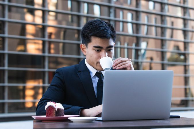Businessman eating dessert in street cafe