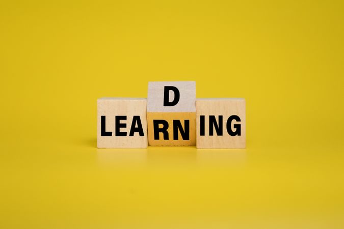 leading and learning words symbol on wooden blocks on yellow background