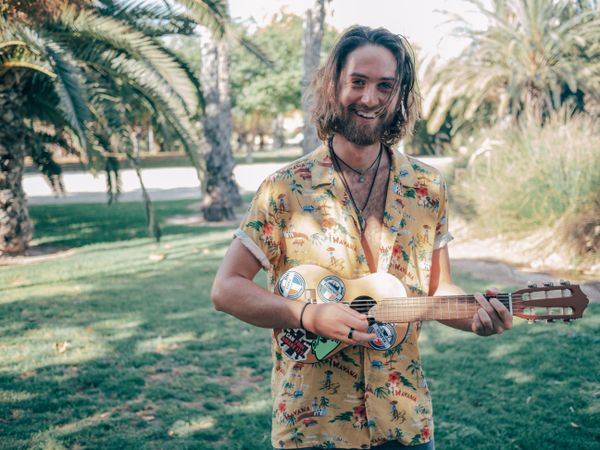 Hipster man in jungle with ukulele