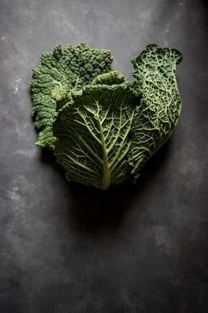 Woman holding fresh cabbage on table
