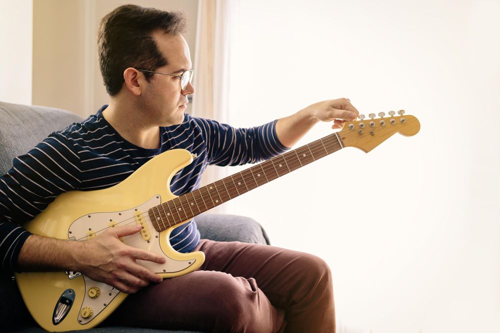 Man tuning an electric guitar