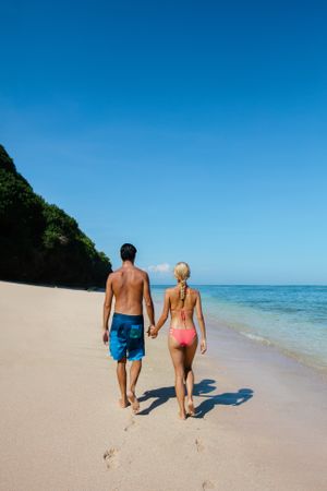Honeymoon couple walking along the sea shore