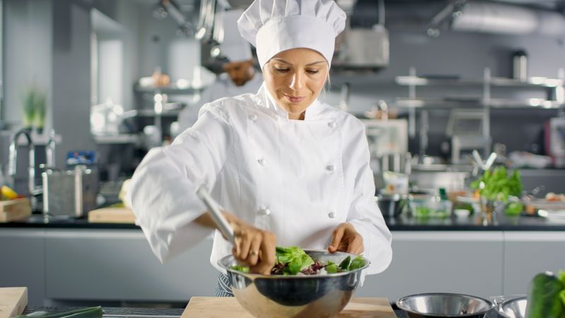 In a Famous Restaurant Female Cook Prepares Salad. She Works in a Big Modern Kitchen.