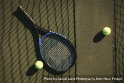 Close up shot of tennis racket and balls lying on the court 4NVyg4
