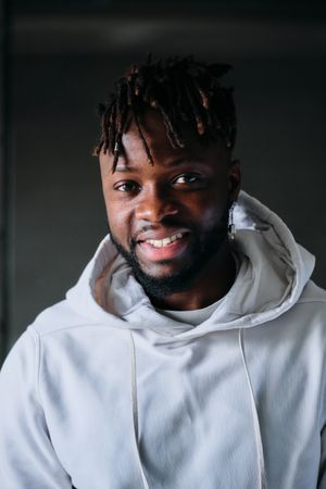 Cheerful Black man in hoodie looking at camera