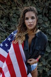 Young woman in casual clothing and American ensign enjoying in nature