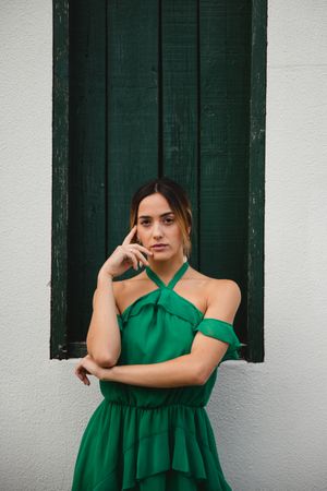Barefoot woman leaning on house wall