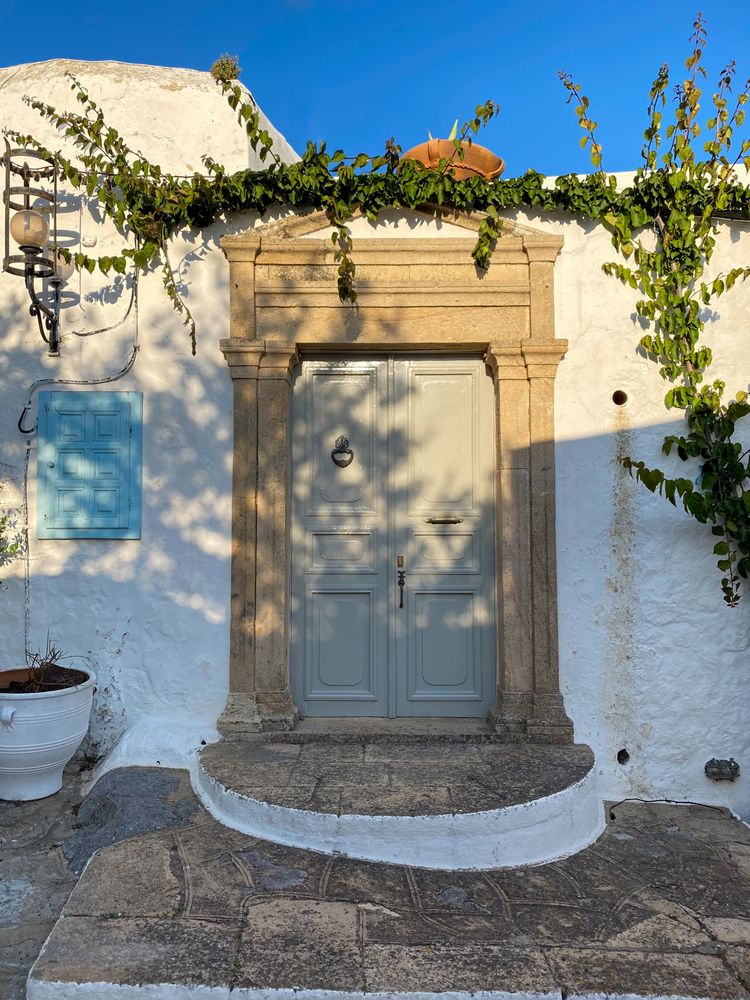 Patmian grey door triangular arch at dusk