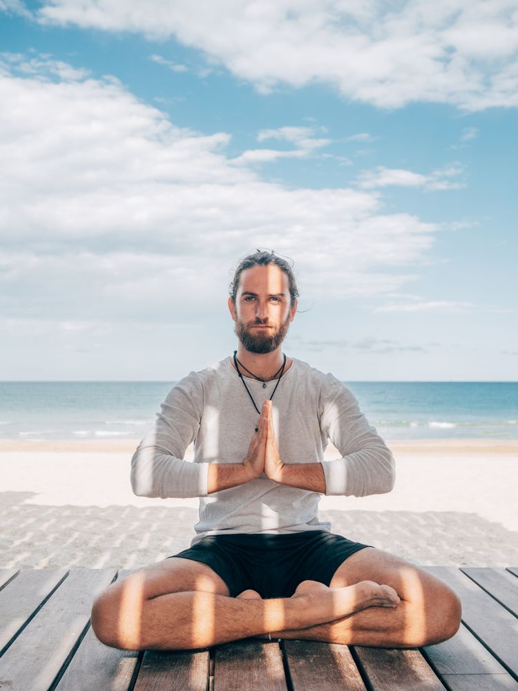 Man meditating on beach